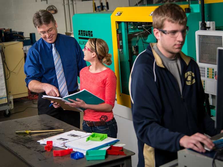 Two students learn from a professor in an engineering lab at Penn State Behrend in Erie, PA.