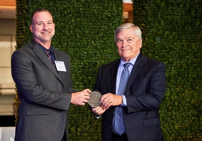 Matthew Totzke receives the Penn State Alumni Fellow Award from Penn State President Eric Barron